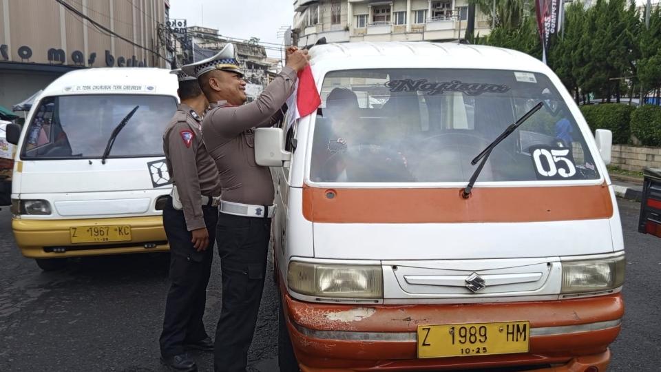 Jelang HUT ke-80 RI, Polsek Cihideung Menyapa Bagikan Bendera Merah Putih kepada Pengguna Jalan